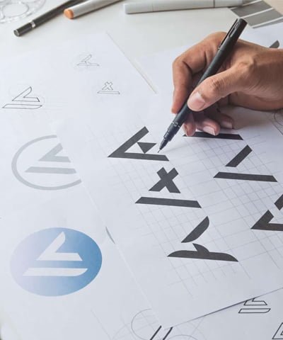 Person trying to choose logo design from typography sheet